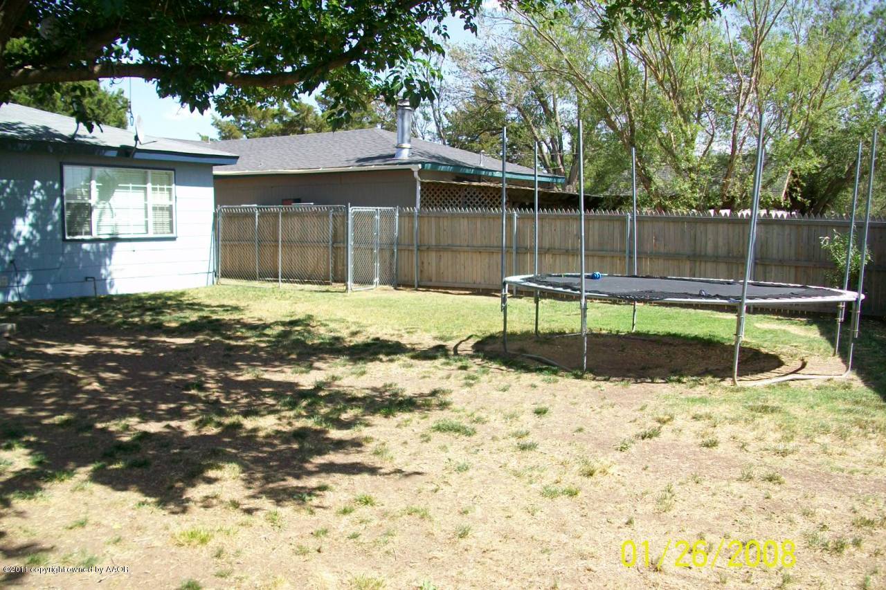 4412 South Bonham Street Amarillo, TX 79110 - Photo 5 of 26 a wooden bench sitting in the middle of a yard