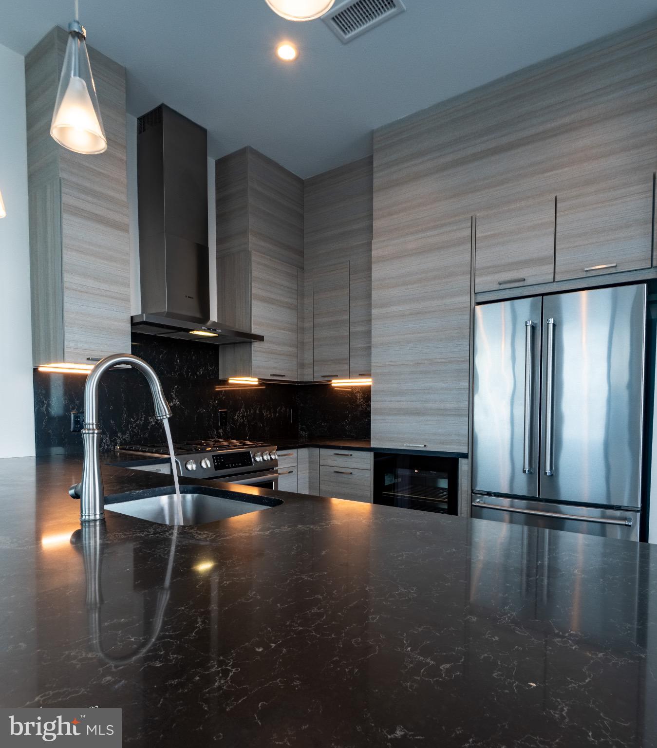 414 Light Street, Unit 4302 Baltimore, MD 21202 - Photo 11 of 42 a kitchen with granite countertop a stove and a refrigerator