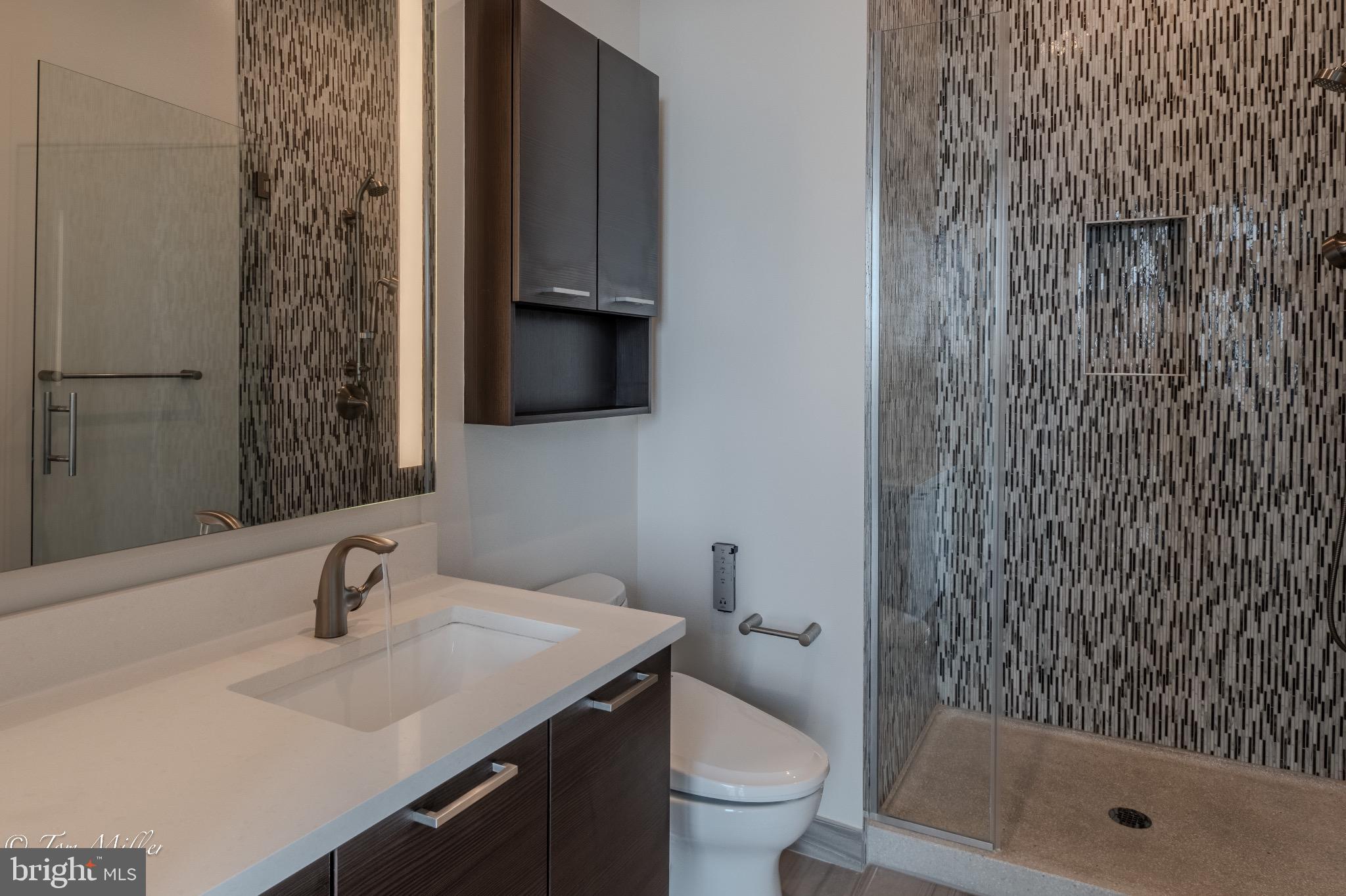 414 Light Street, Unit 4302 Baltimore, MD 21202 - Photo 25 of 42 a bathroom with a sink toilet a mirror and shower