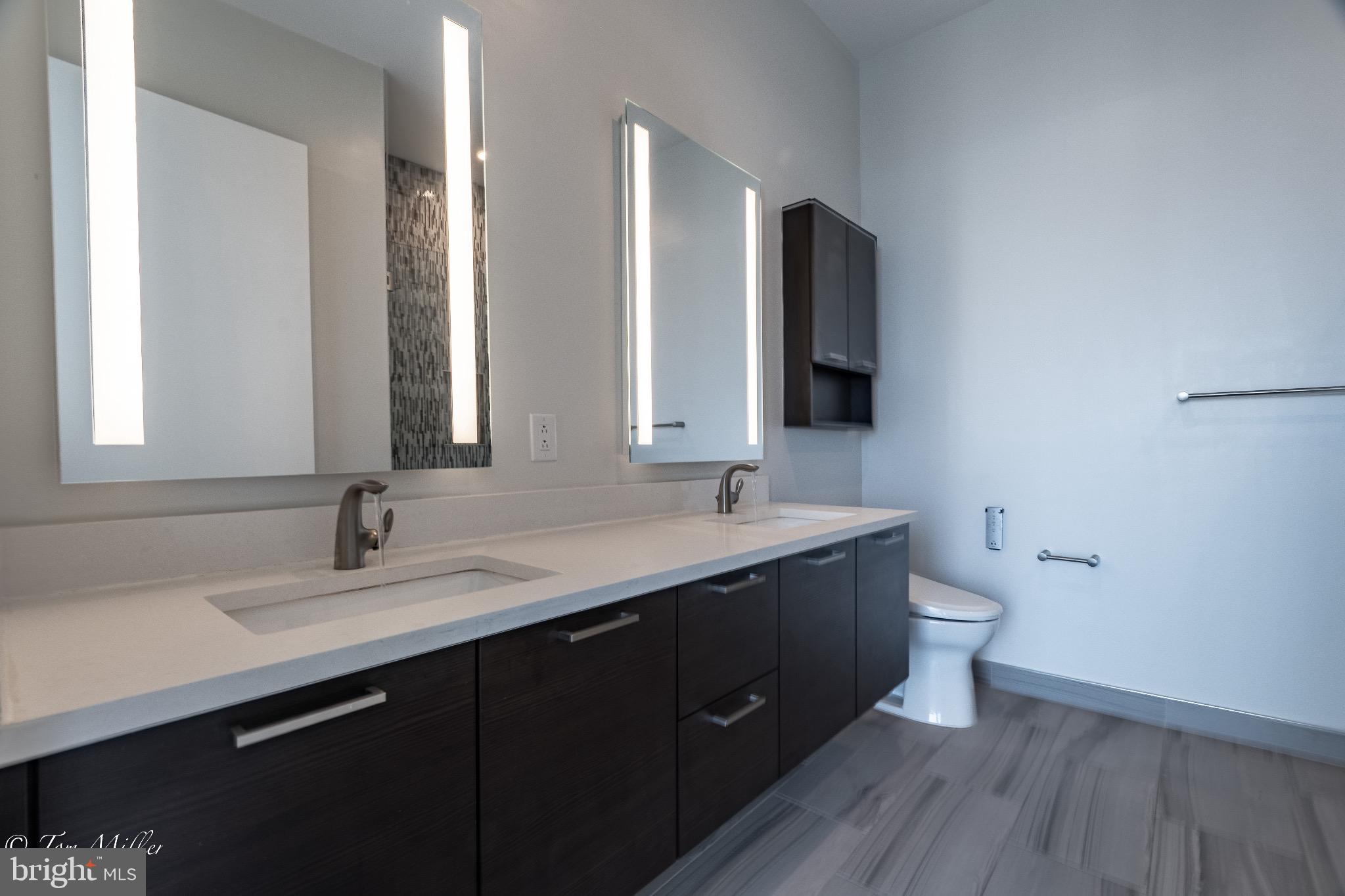 414 Light Street, Unit 4302 Baltimore, MD 21202 - Photo 29 of 42 a bathroom with a double vanity sink and mirror