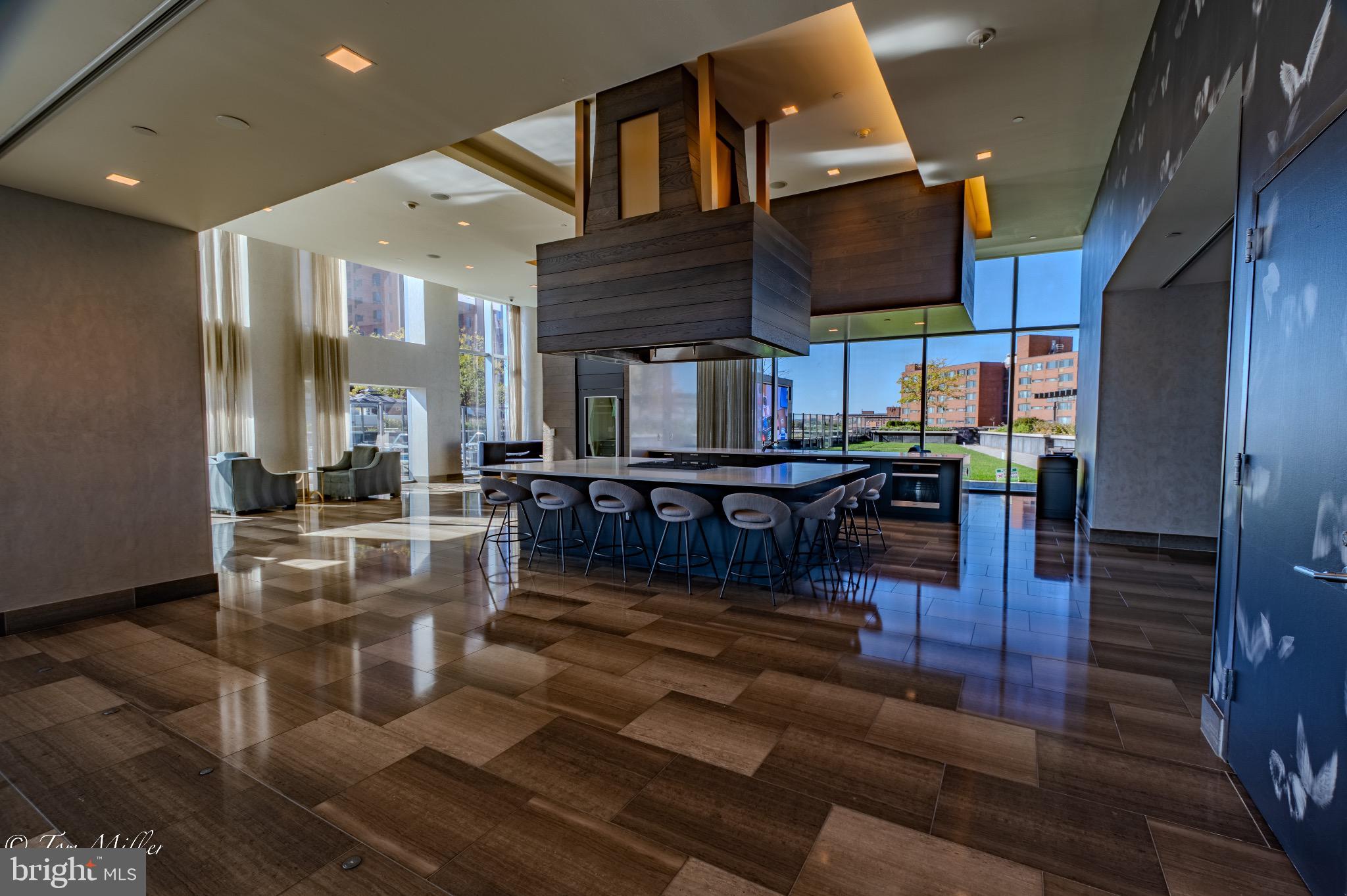 414 Light Street, Unit 4302 Baltimore, MD 21202 - Photo 38 of 42 a living room with couches chairs and kitchen view with wooden floor