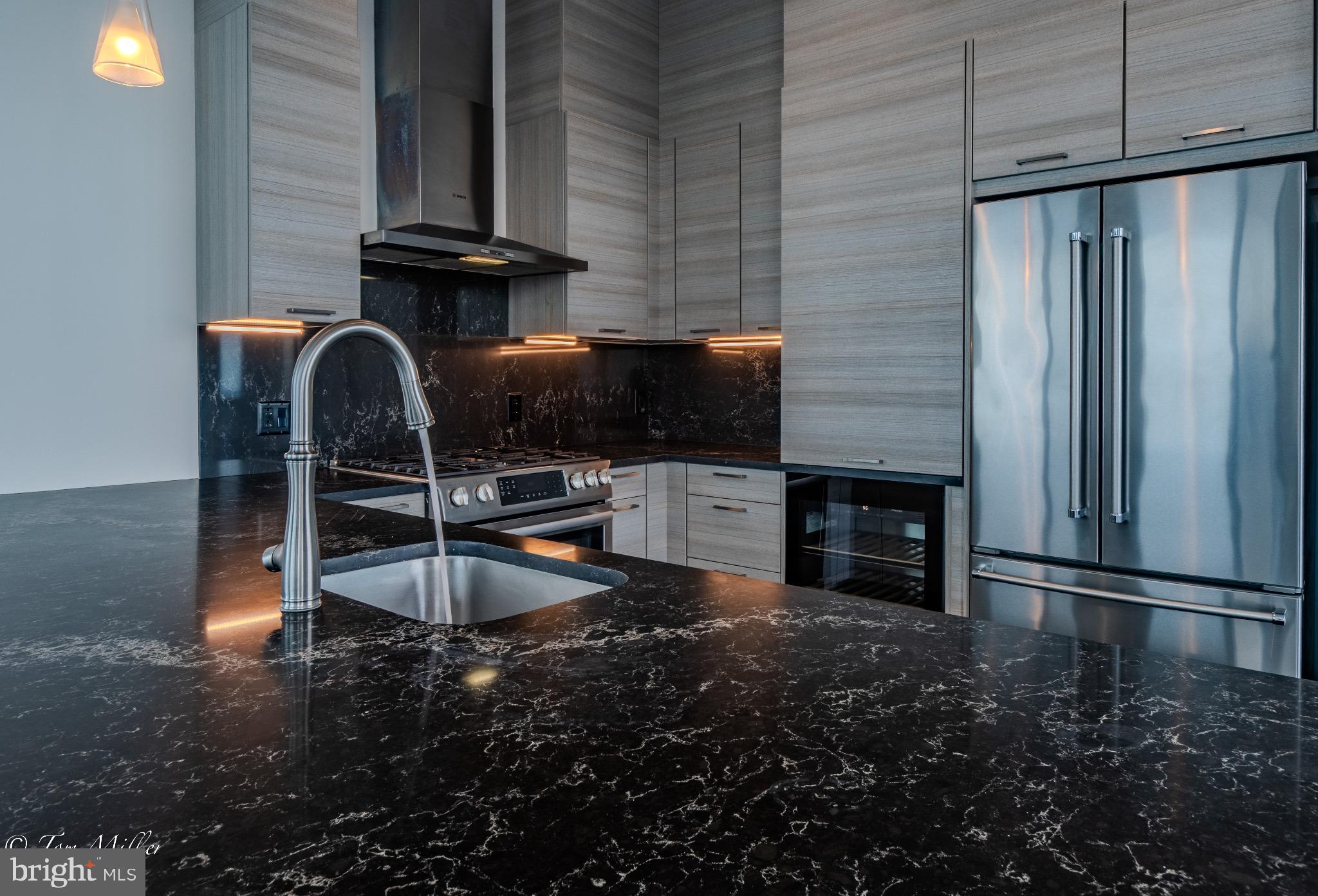 414 Light Street, Unit 4302 Baltimore, MD 21202 - Photo 8 of 42 a kitchen with granite countertop a stove a microwave and a refrigerator