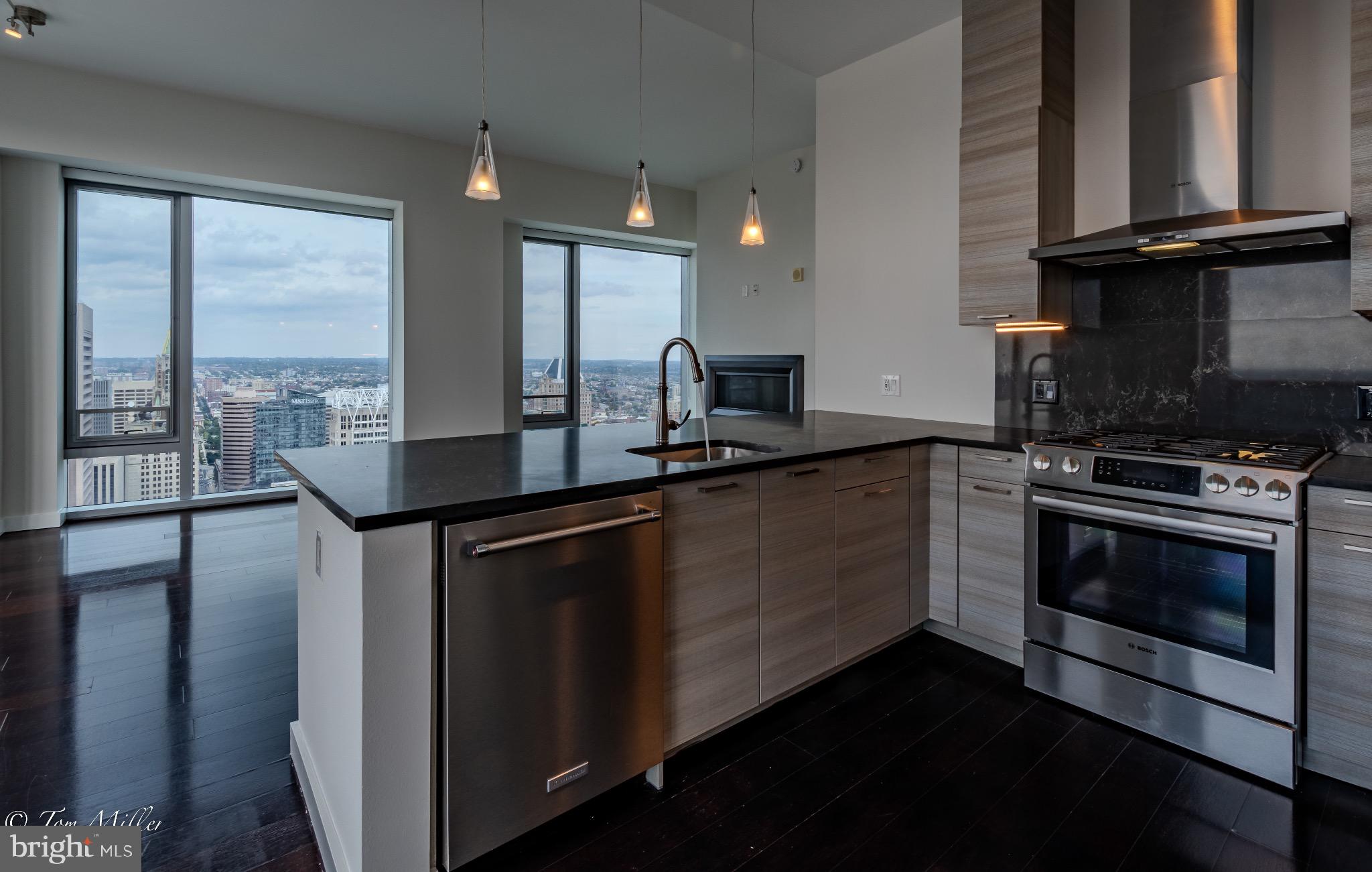 414 Light Street, Unit 4302 Baltimore, MD 21202 - Photo 10 of 42 a kitchen with stainless steel appliances granite countertop a stove a sink and a granite counter tops with a granite countertops