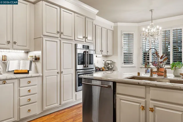 a kitchen with stainless steel appliances granite countertop a sink a refrigerator a center island and cabinets