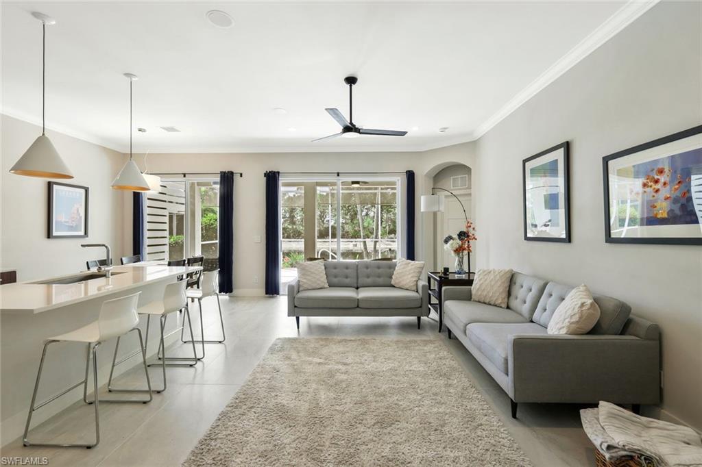 5717 Lago Villaggio Way Naples, FL 34104 - Photo 11 of 35 a living room with furniture and a chandelier