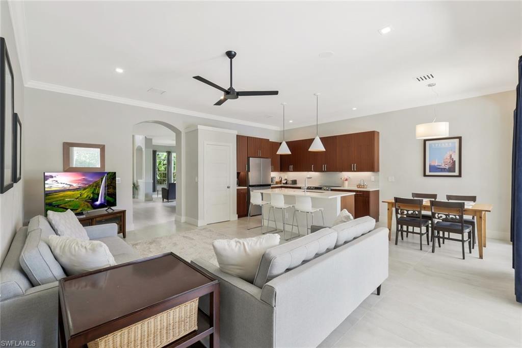 5717 Lago Villaggio Way Naples, FL 34104 - Photo 12 of 35 a living room with furniture kitchen view and a chandelier
