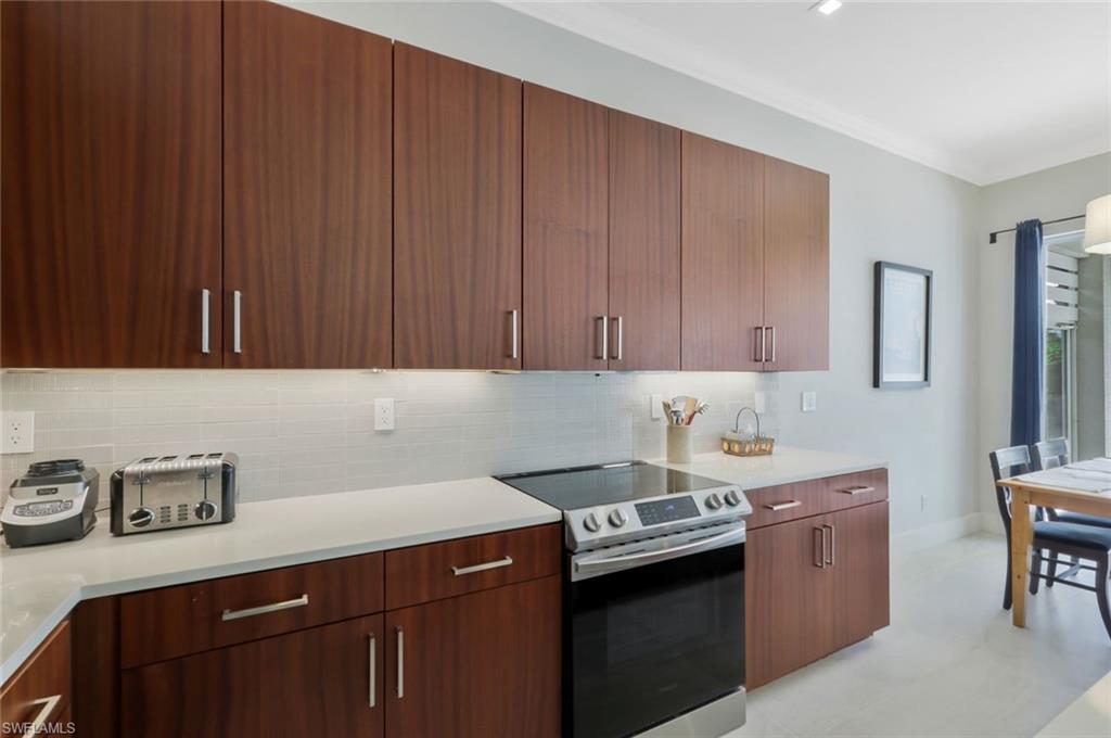 5717 Lago Villaggio Way Naples, FL 34104 - Photo 17 of 35 a kitchen with a sink cabinets and appliances