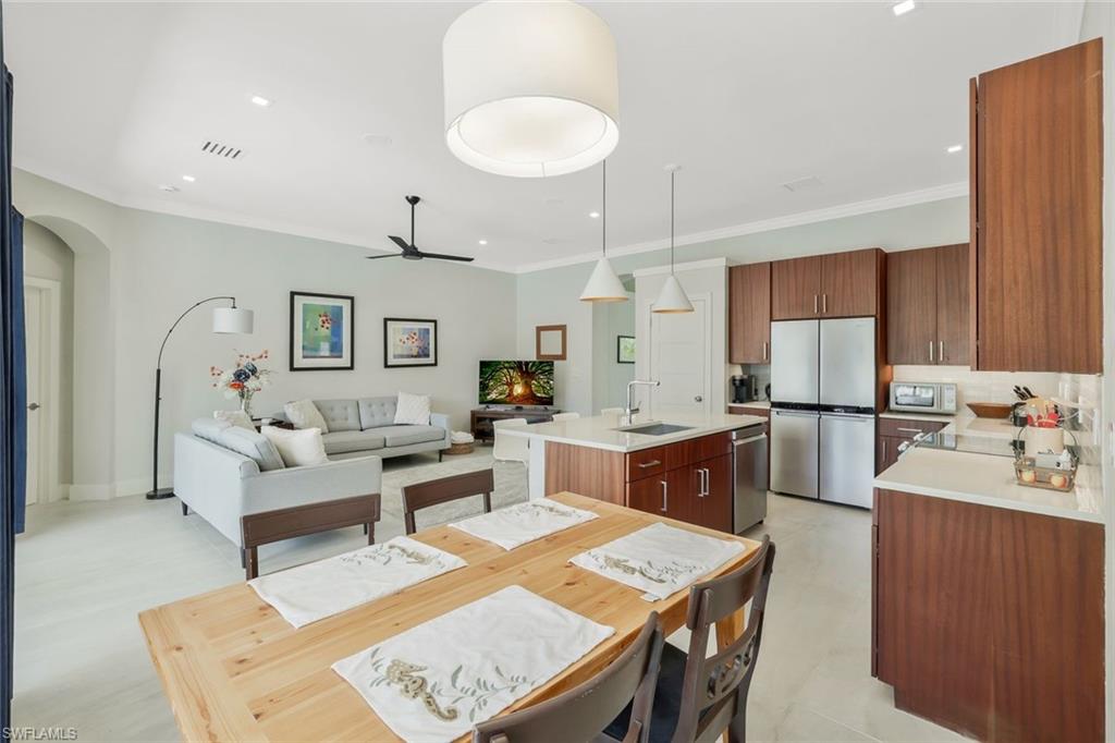5717 Lago Villaggio Way Naples, FL 34104 - Photo 20 of 35 a large white kitchen with a table and chairs