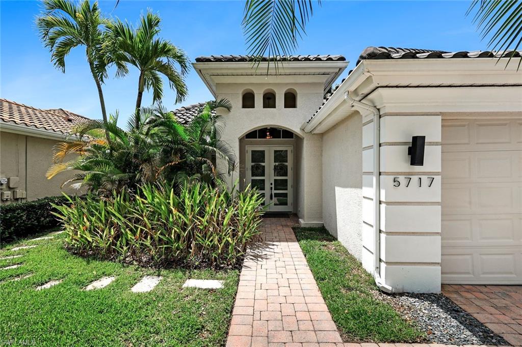 5717 Lago Villaggio Way Naples, FL 34104 - Photo 2 of 35 a front view of a house with garden