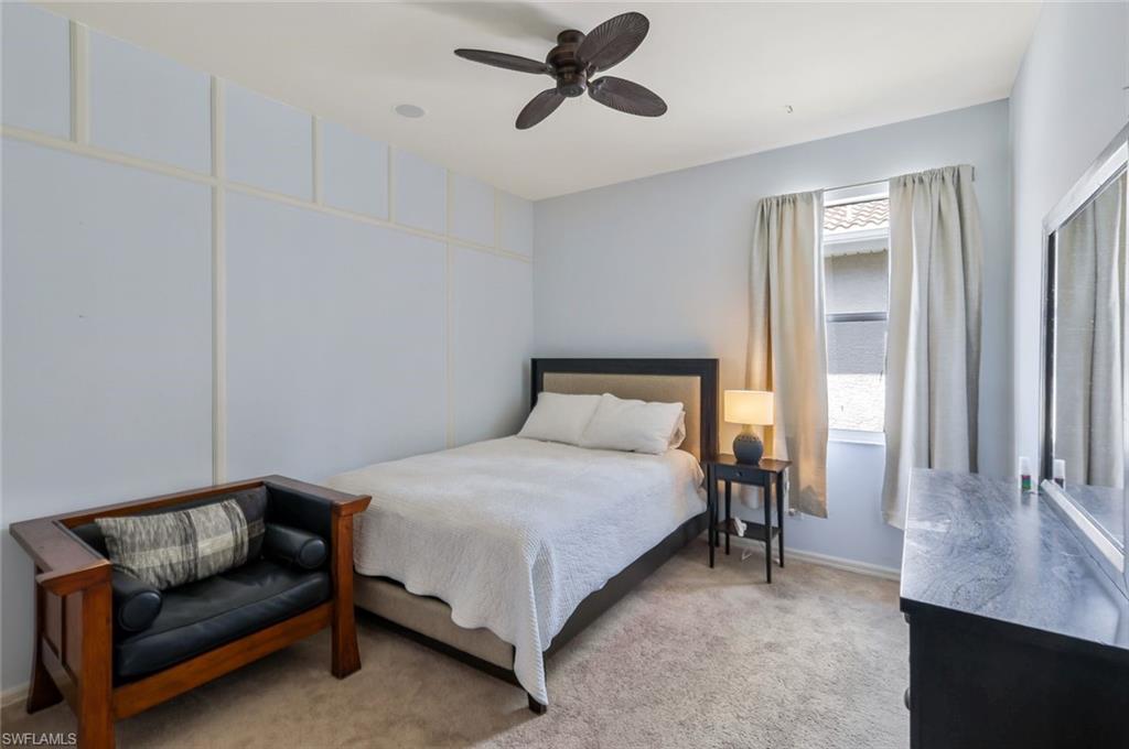 5717 Lago Villaggio Way Naples, FL 34104 - Photo 27 of 35 a bedroom with a bed couch and window