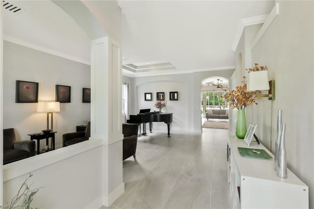 5717 Lago Villaggio Way Naples, FL 34104 - Photo 3 of 35 a living room with furniture and a flat screen tv