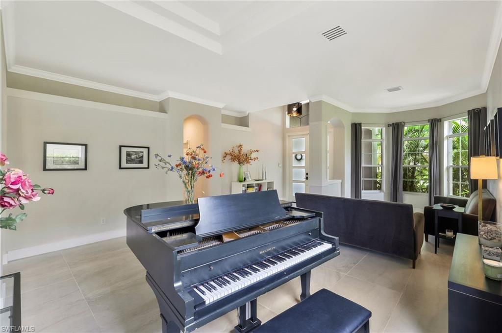 5717 Lago Villaggio Way Naples, FL 34104 - Photo 7 of 35 a living room with furniture a piano and a potted plant