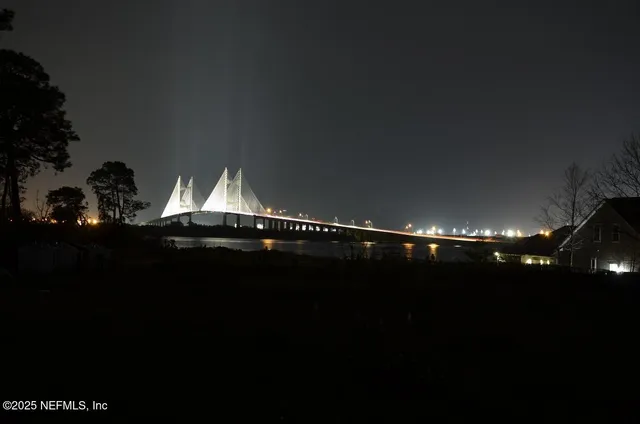 a view of a hallway with wooden floor and a bathroom
