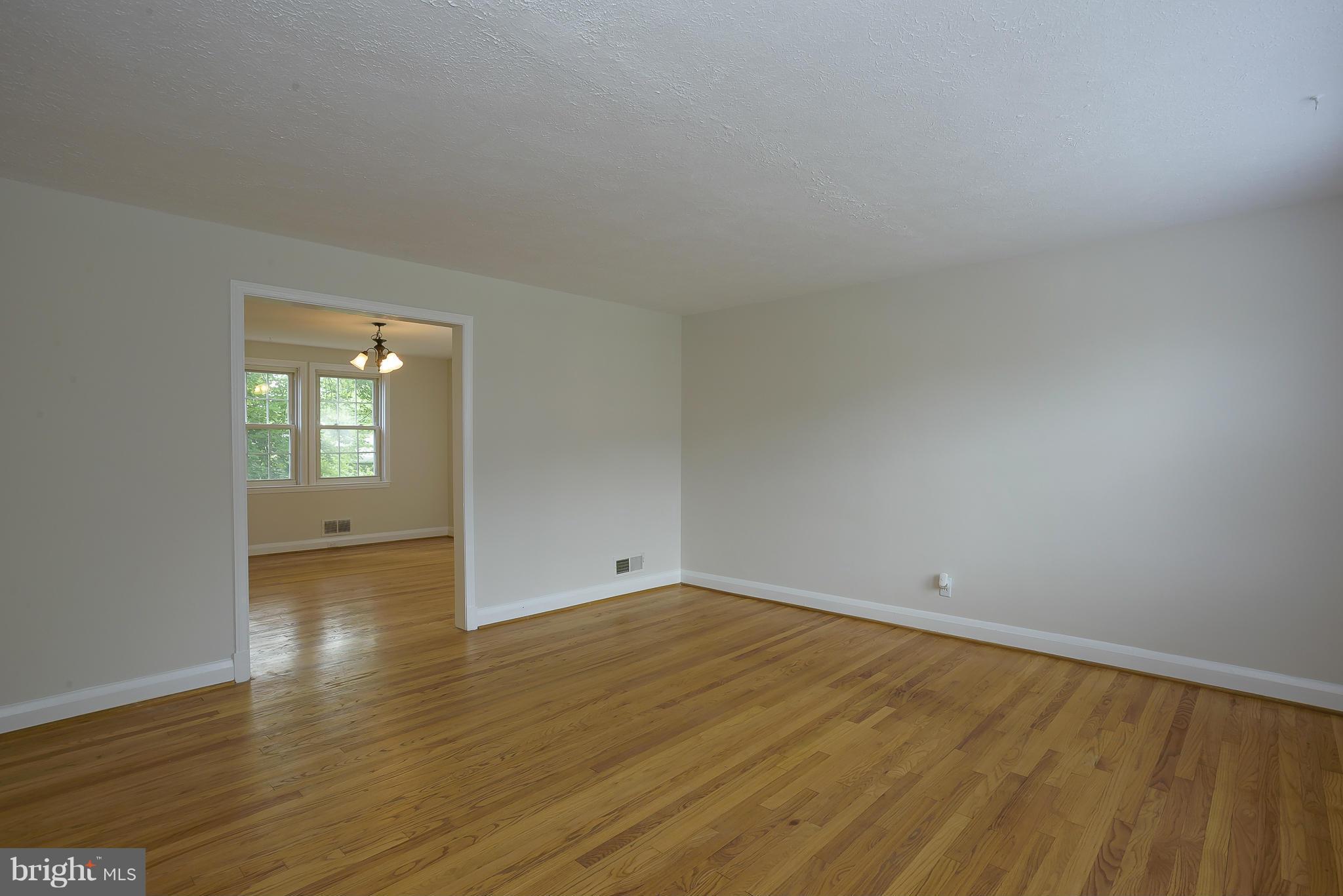 6125 Regent Park Road Catonsville, MD 21228 - Photo 5 of 25 an empty room with wooden floor and windows