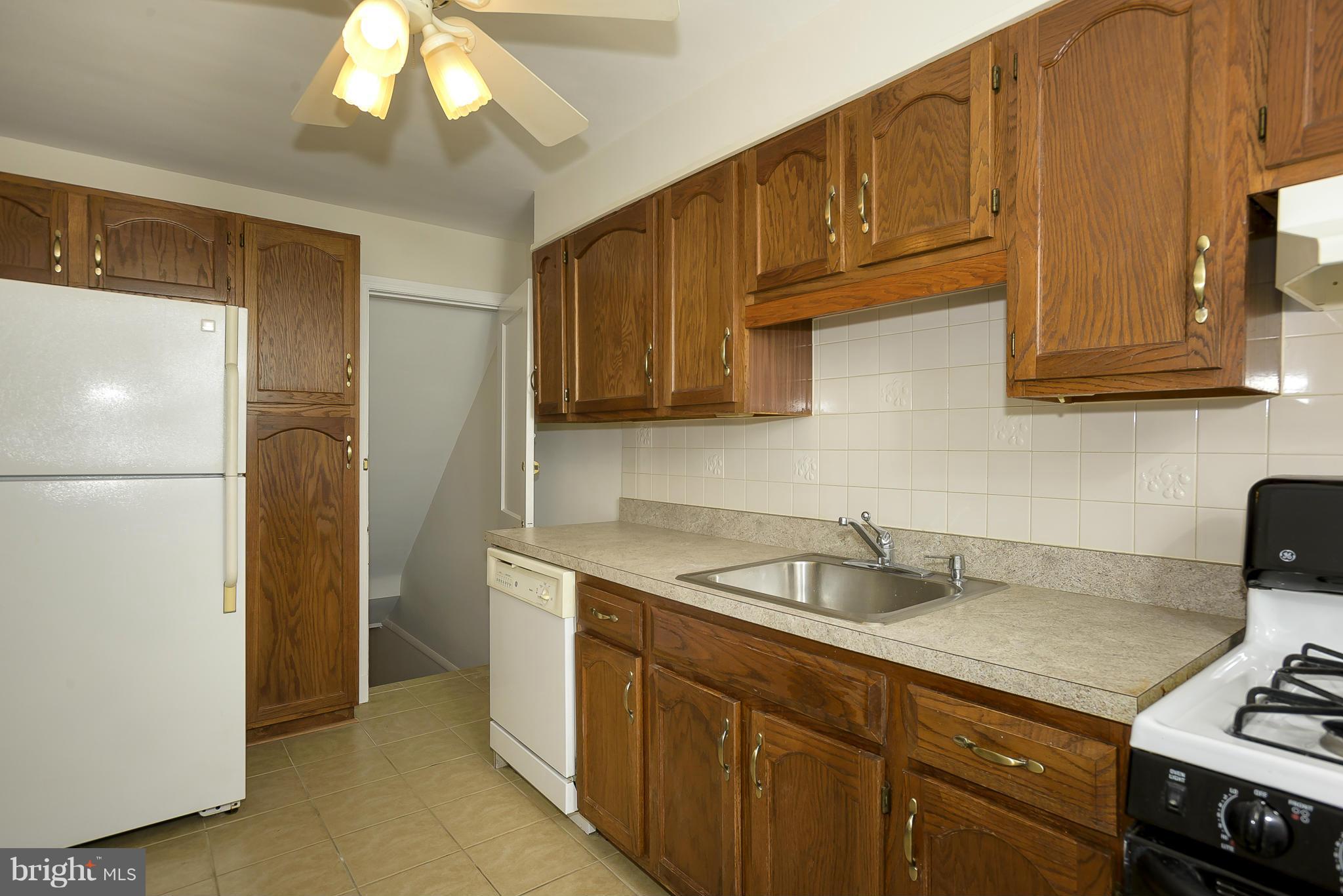 6125 Regent Park Road Catonsville, MD 21228 - Photo 9 of 25 a kitchen with stainless steel appliances granite countertop a sink refrigerator and cabinets