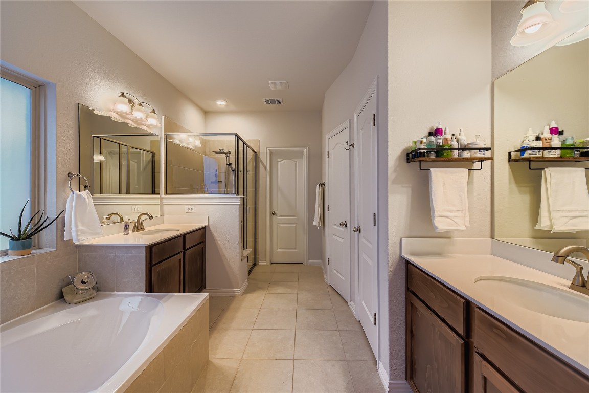 1075 Cherrystone Loop Buda, TX 78610 - Photo 15 of 28 a spacious bathroom with a sink double vanity and a mirror