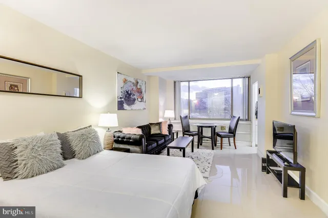 a bedroom with furniture and a large window