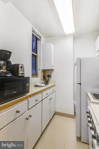 a kitchen with stainless steel appliances white cabinets and a refrigerator