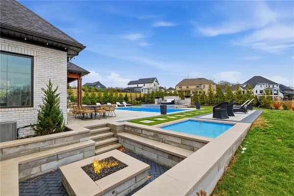 a view of a house with swimming pool and a chairs