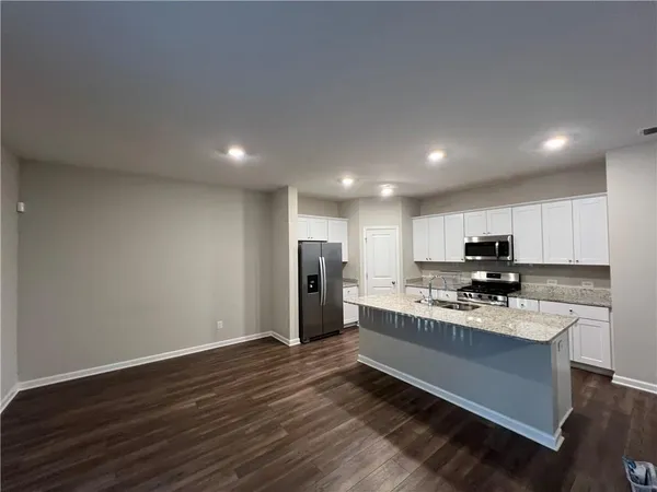 a kitchen with a refrigerator and a stove top oven