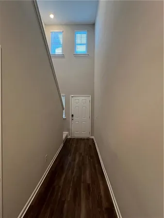 a view of a hallway with wooden floor and staircase