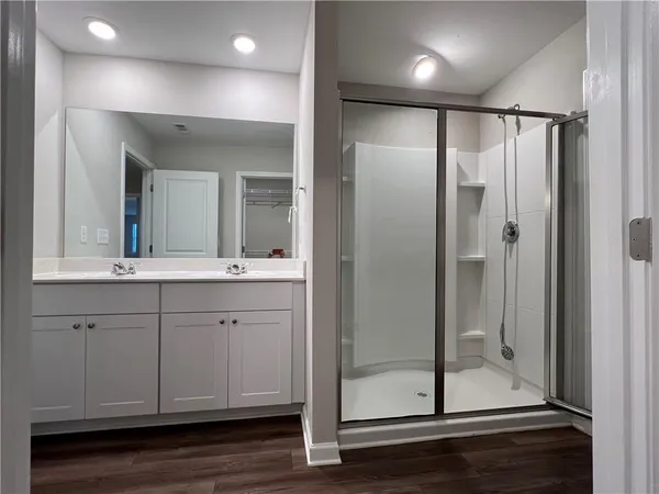 a bathroom with a shower sink and mirror