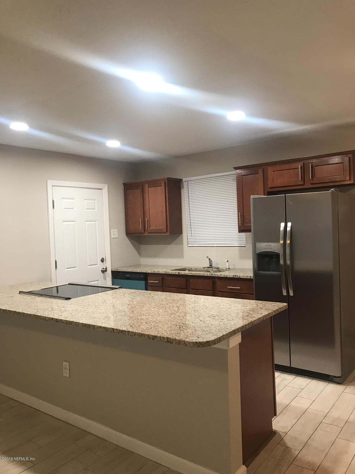 4705 Ruckner Road Jacksonville, FL 32207 - Photo 8 of 24 a kitchen with kitchen island a counter top a sink and a refrigerator