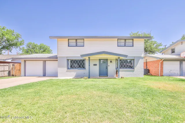 a view of a house with a yard and a garage