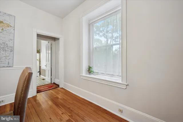 a view of a room with wooden floor and a window