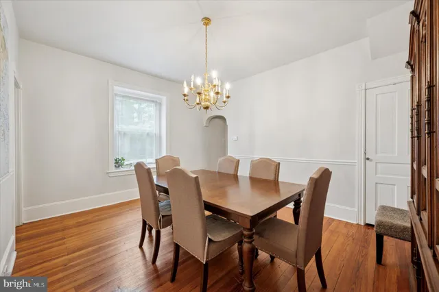 a dining room with furniture a chandelier and wooden floor