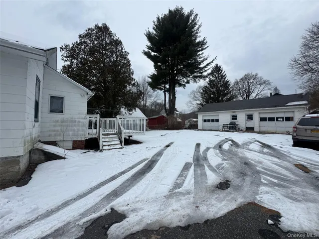 a dirt road with house in the background