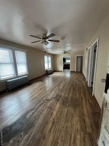 a view of a livingroom with wooden floor and a ceiling fan