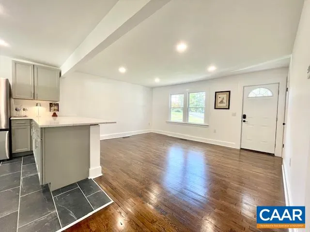 a view of a kitchen with fridge and wooden floor