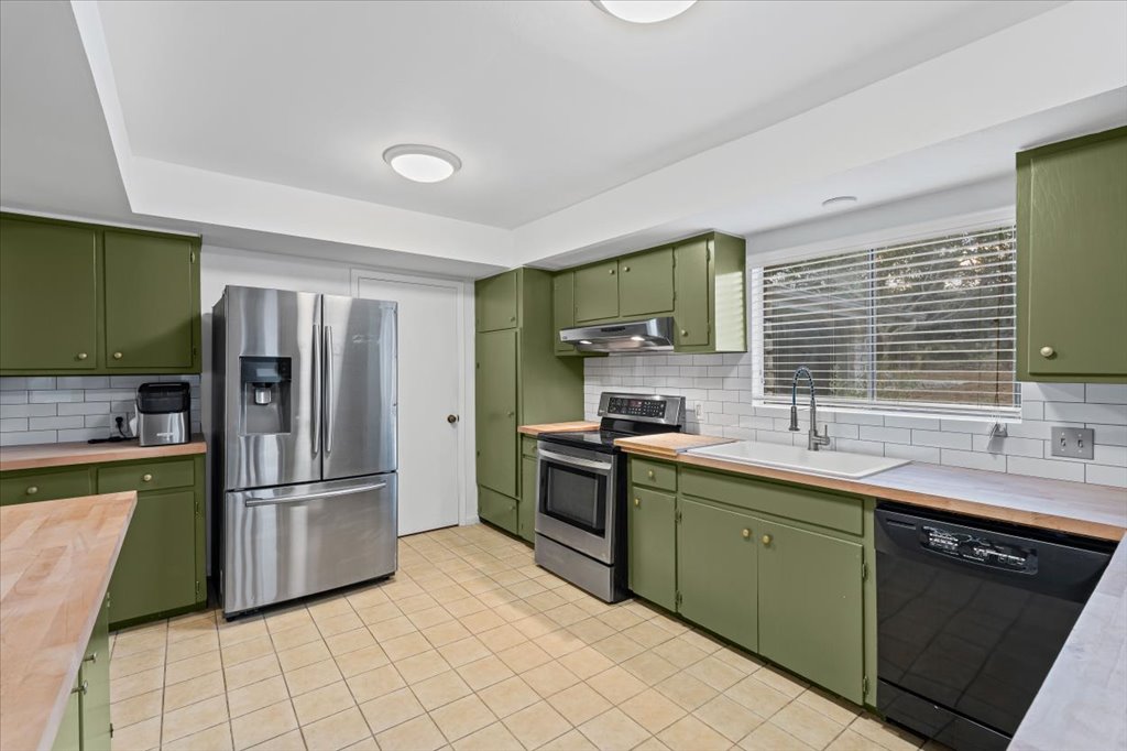 313 Comet Lakeway, TX 78734 - Photo 4 of 17 Kitchen featuring painted cabinetry, stainless steel appliances, wooden counters, and backsplash