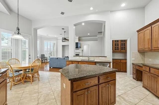 a kitchen with granite countertop a table and chairs in it