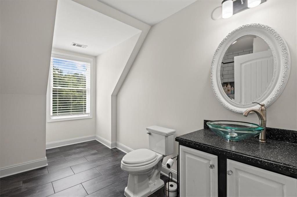 3002 Highway 101 Rockmart, GA 30153 - Photo 38 of 78 a bathroom with a granite countertop toilet a sink and a mirror
