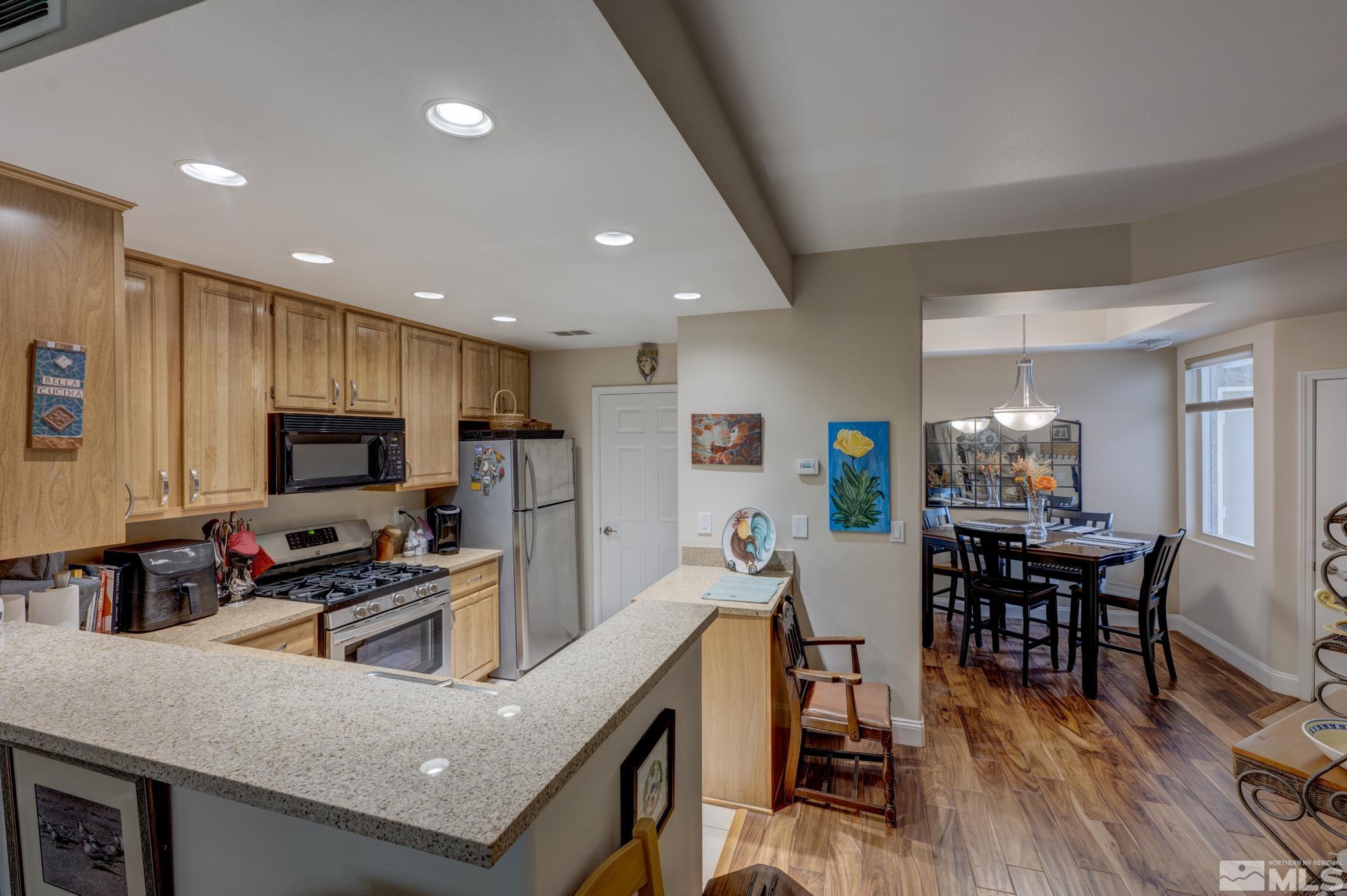900 S Meadows, Unit 613 Reno, NV 89521 - Photo 11 of 40 a kitchen with a table chairs refrigerator and microwave