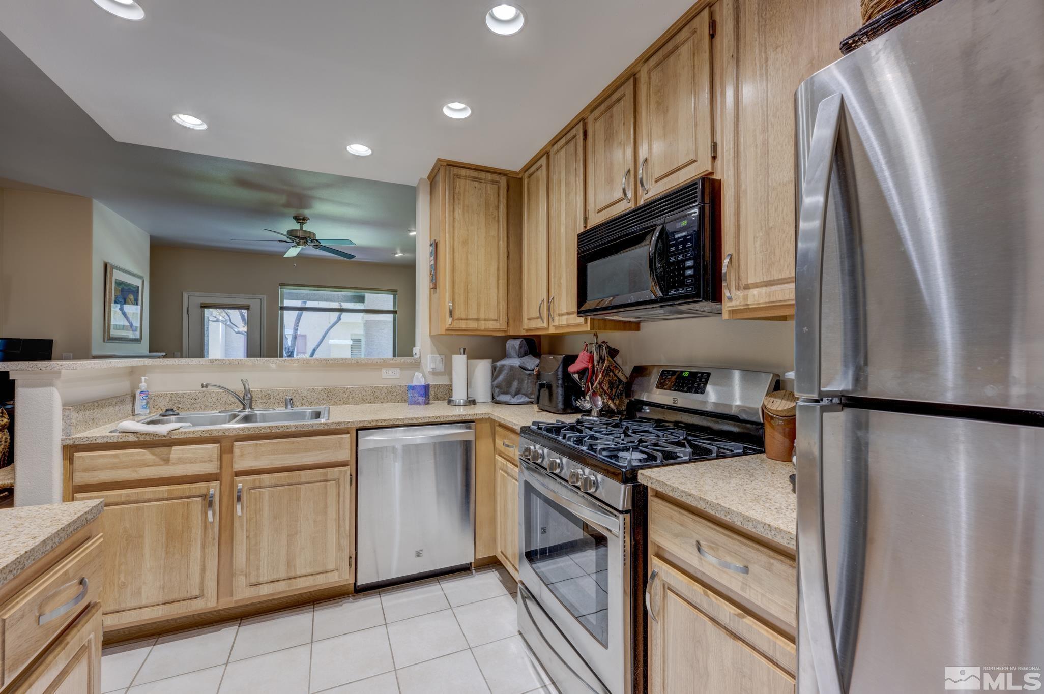 900 S Meadows, Unit 613 Reno, NV 89521 - Photo 13 of 40 a kitchen with granite countertop a sink stove and refrigerator