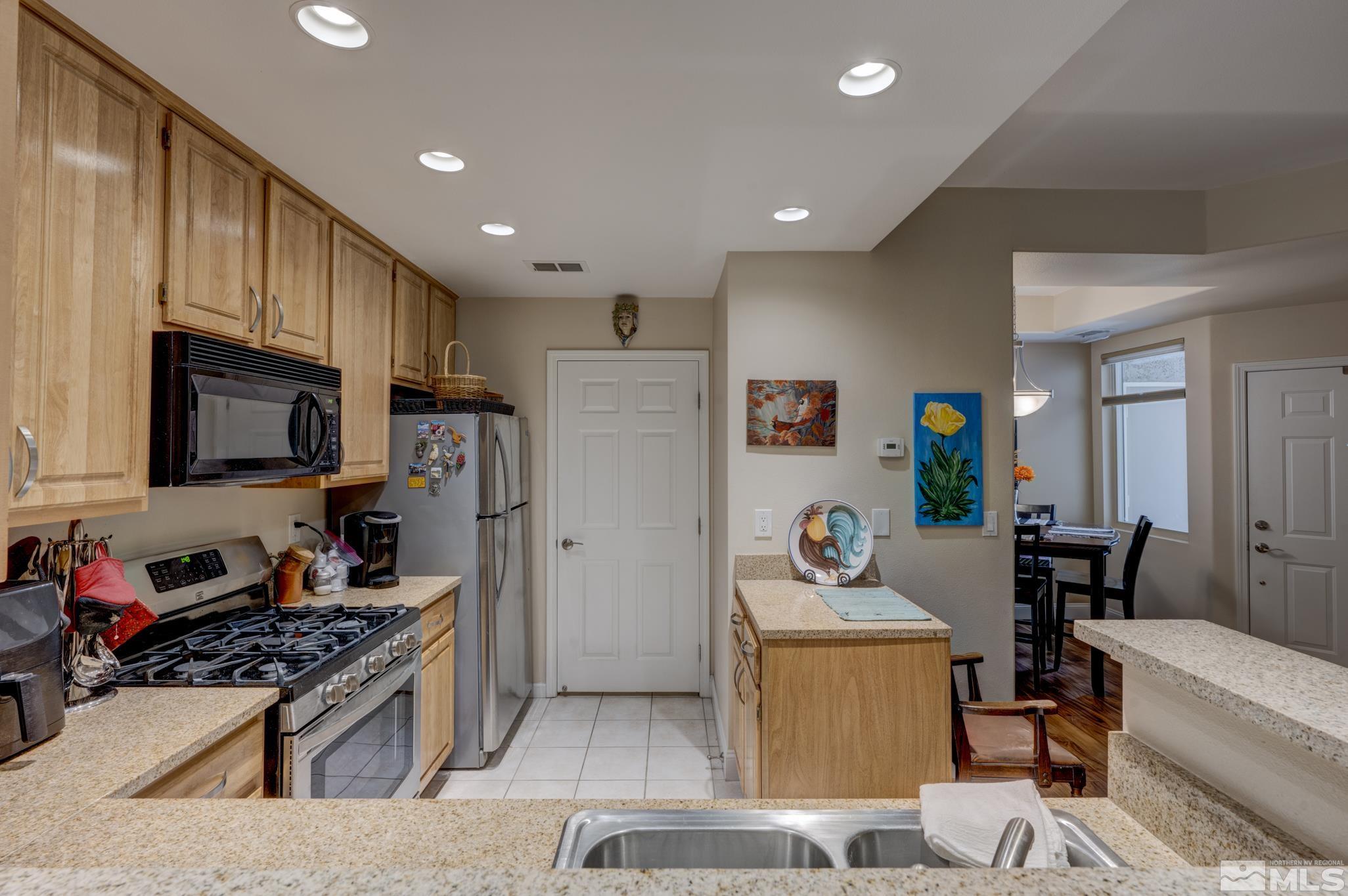 900 S Meadows, Unit 613 Reno, NV 89521 - Photo 17 of 40 a kitchen with stainless steel appliances granite countertop a stove and a refrigerator