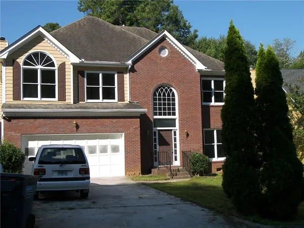 a view of a house with a yard and potted plants