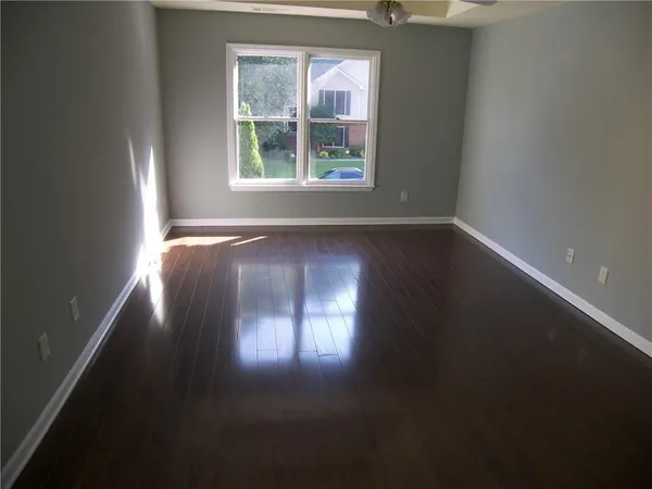 a view of wooden floor and windows in an empty room