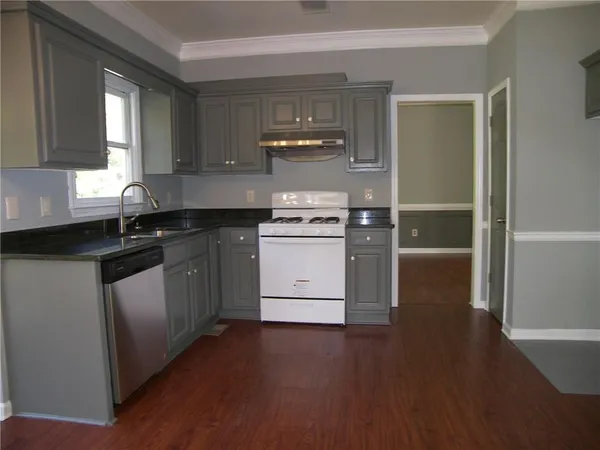 a kitchen with a sink stove and cabinets
