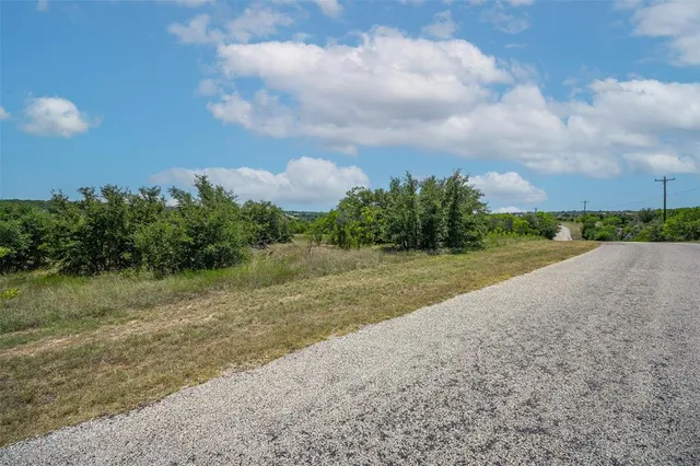 a view of a field with trees in background
