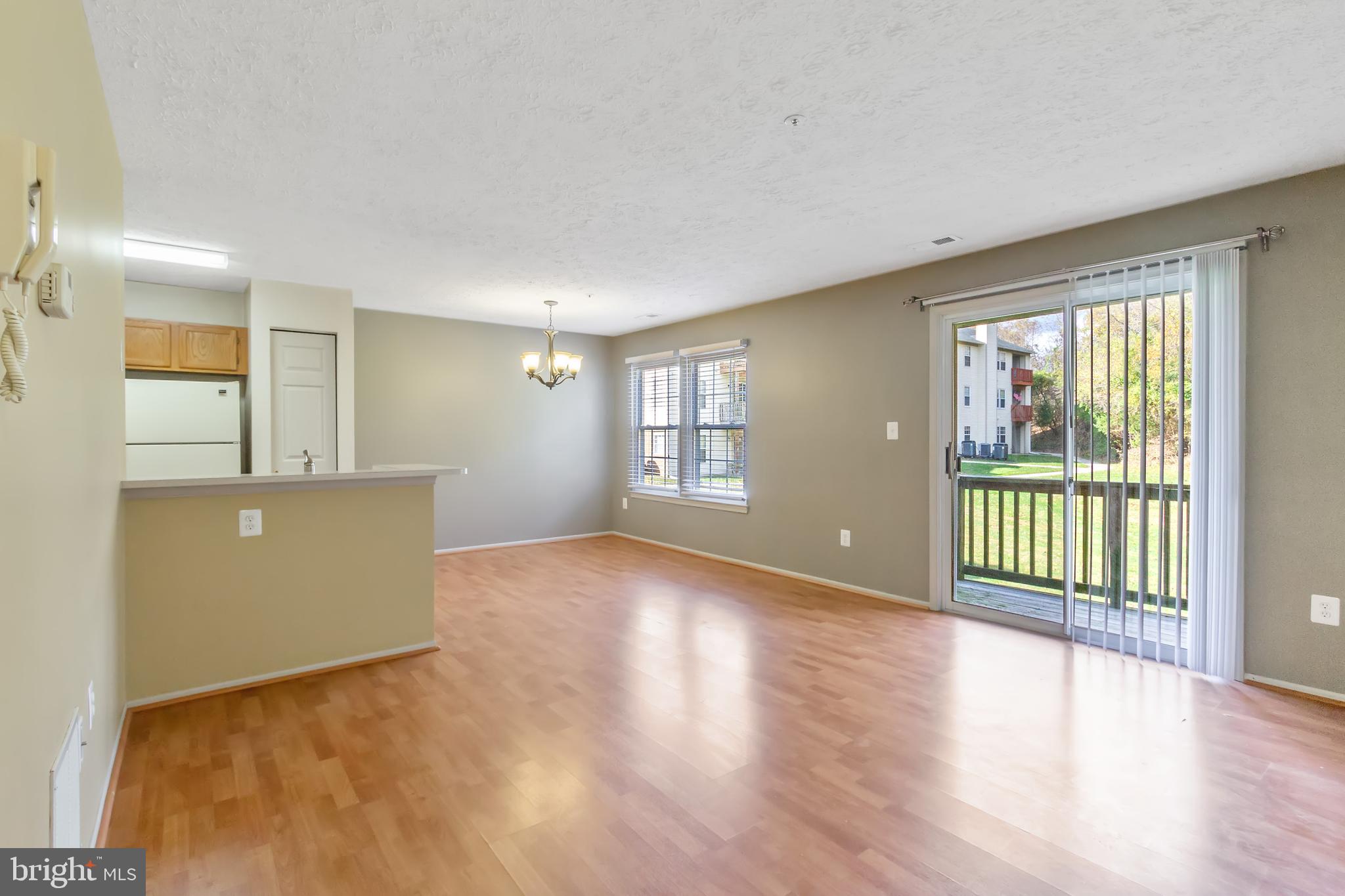96 Jumpers Circle, Unit 216 Baltimore, MD 21236 - Photo 1 of 29 a view of an empty room with wooden floor and a window