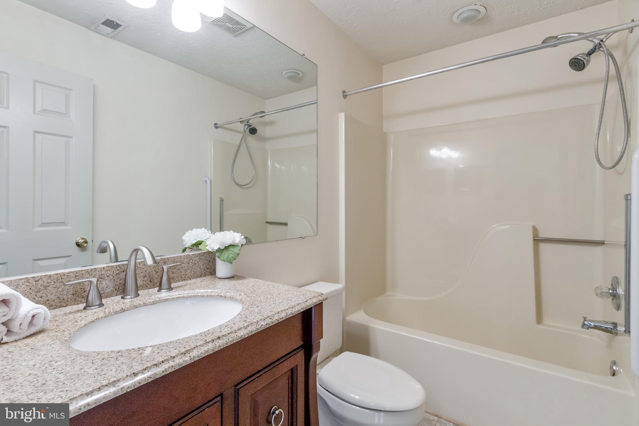 96 Jumpers Circle, Unit 216 Baltimore, MD 21236 - Photo 18 of 29 a bathroom with a granite countertop sink toilet mirror and shower