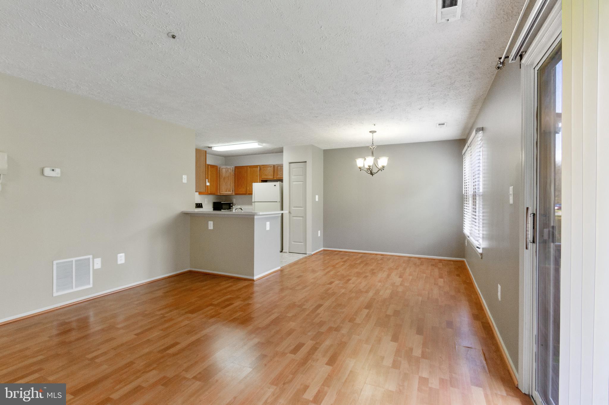 96 Jumpers Circle, Unit 216 Baltimore, MD 21236 - Photo 2 of 29 a view of a big room with wooden floor and a kitchen