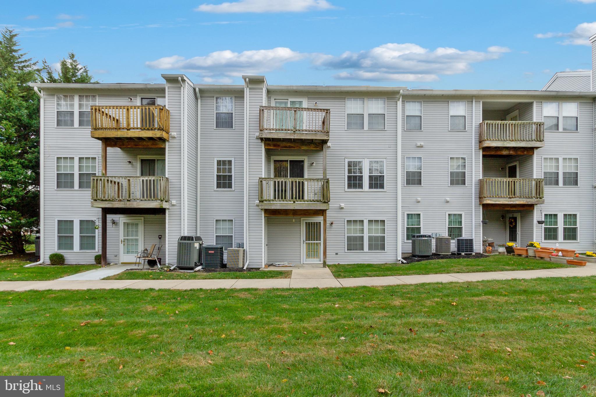 96 Jumpers Circle, Unit 216 Baltimore, MD 21236 - Photo 26 of 29 a front view of a residential apartment building with a yard