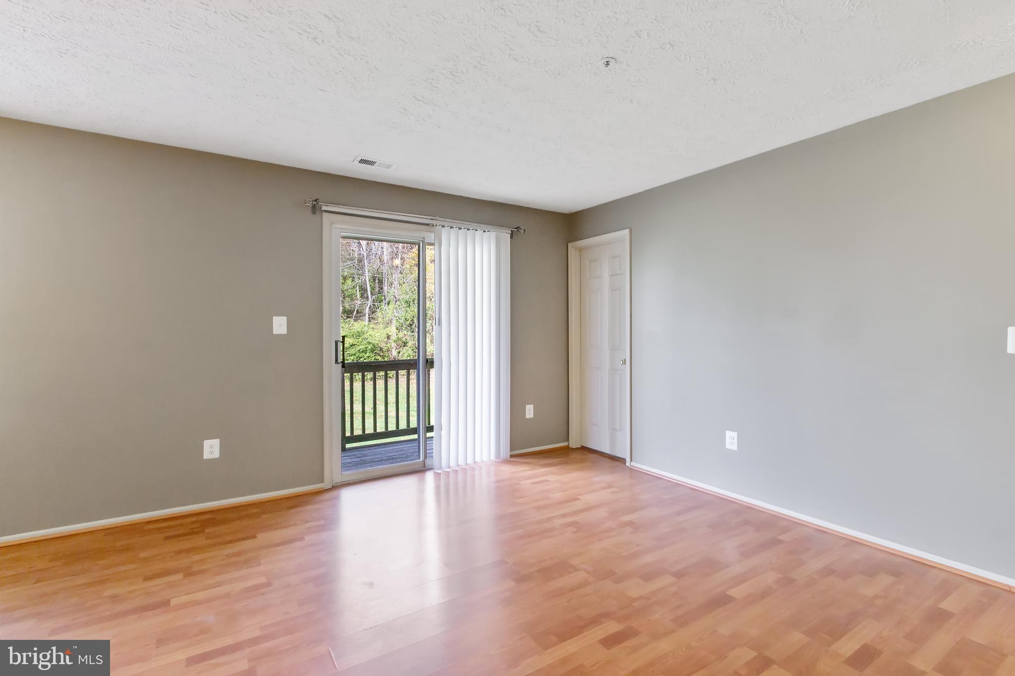 96 Jumpers Circle, Unit 216 Baltimore, MD 21236 - Photo 4 of 29 a view of an empty room with wooden floor and a window