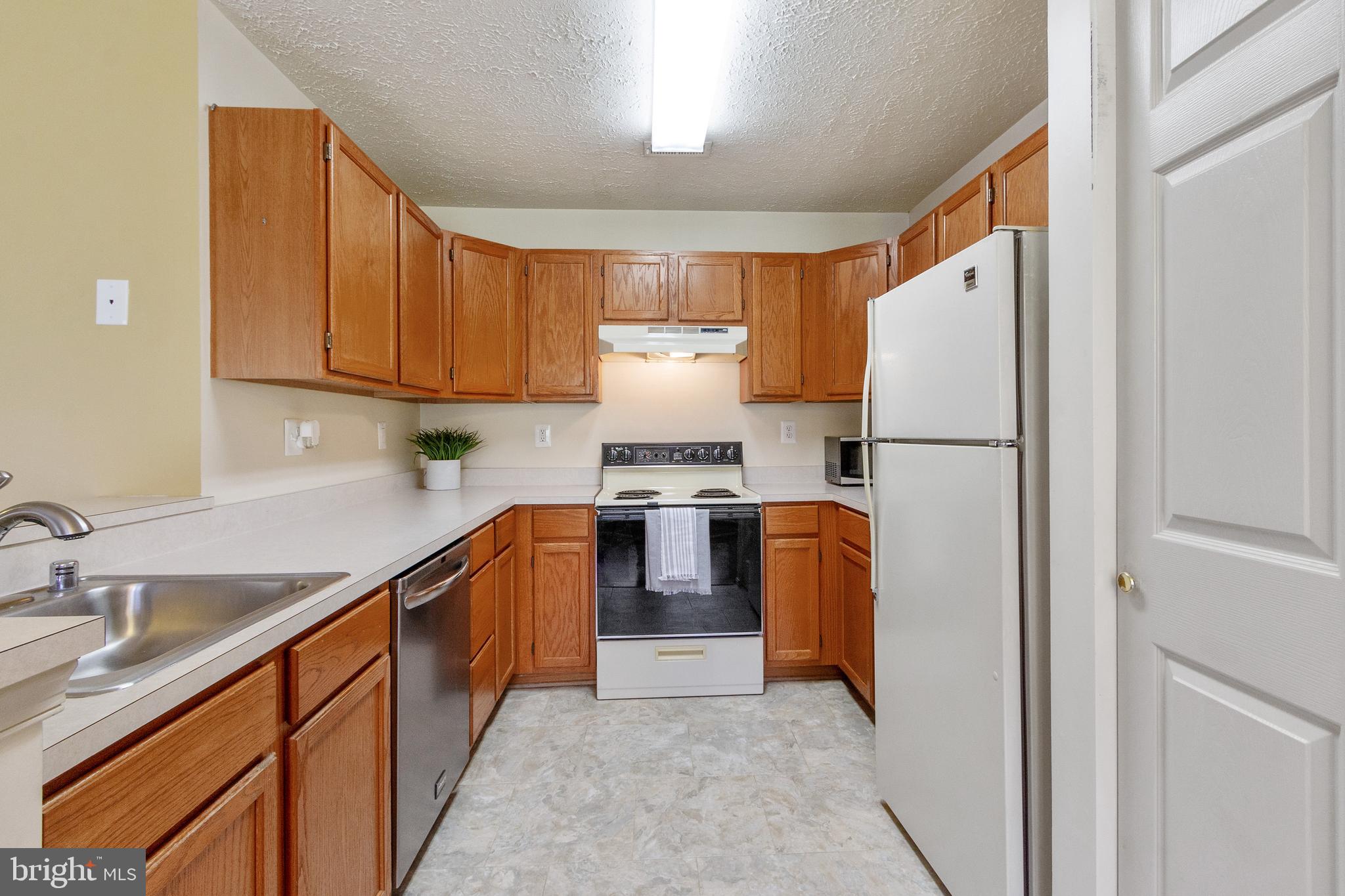 96 Jumpers Circle, Unit 216 Baltimore, MD 21236 - Photo 6 of 29 a kitchen with stainless steel appliances granite countertop a refrigerator a stove and a sink