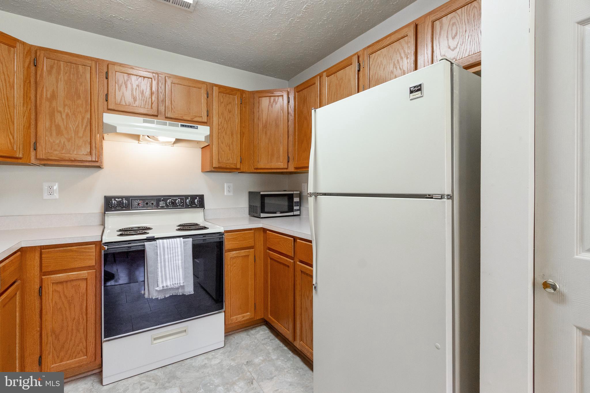 96 Jumpers Circle, Unit 216 Baltimore, MD 21236 - Photo 7 of 29 a kitchen with stainless steel appliances a refrigerator and a stove top oven